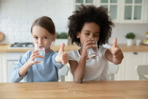 Photo of Portrait of smiling multiethnic girls drink water