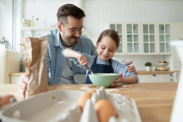 istock Happy dad bake cookies with small daughter 1319314742
