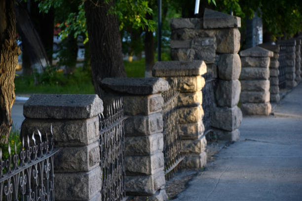 istock Old stone fence with posts in the park 1319315888