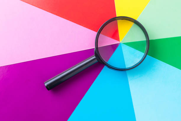 istock Magnifying glass on multi-colored sheets of paper. Search for diversity color combinations. The concept of finding a variety of choices. 1319317643