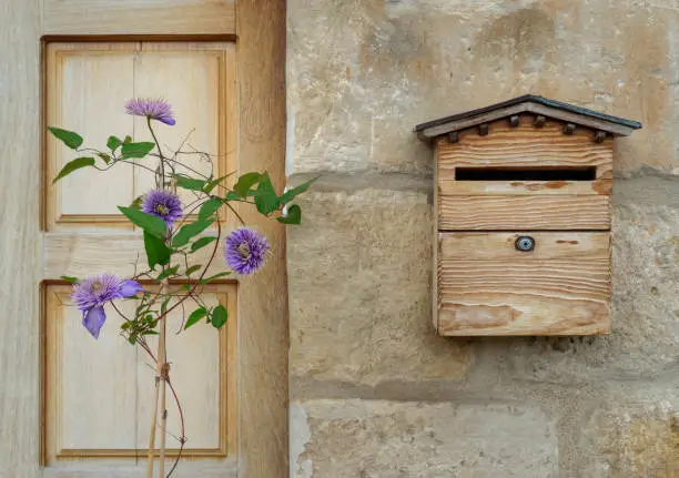 Photo of Village facade with mailbox and purple flowers plant.