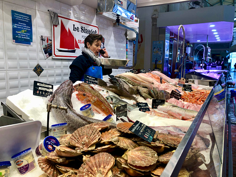 Horizontal photo of a female working on a seafood stall at the Food Market in La Rochelle on the south west coast of France