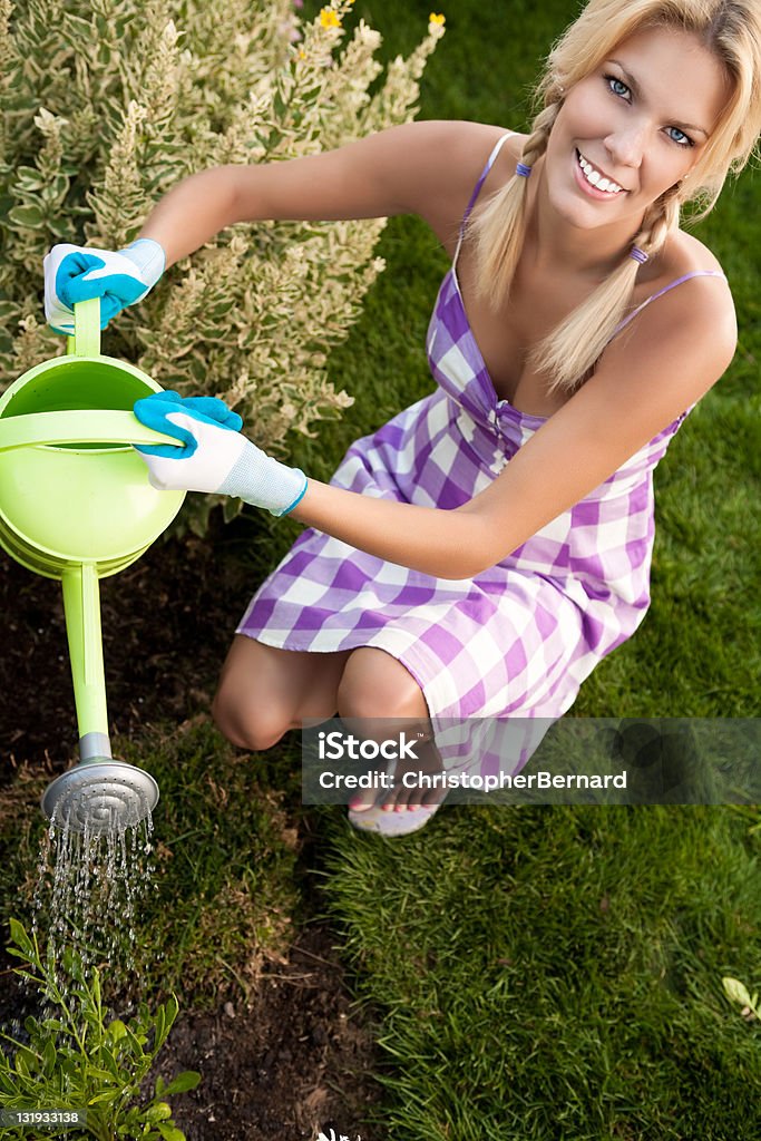 Souriant femme arroser le jardin - Photo de 20-24 ans libre de droits