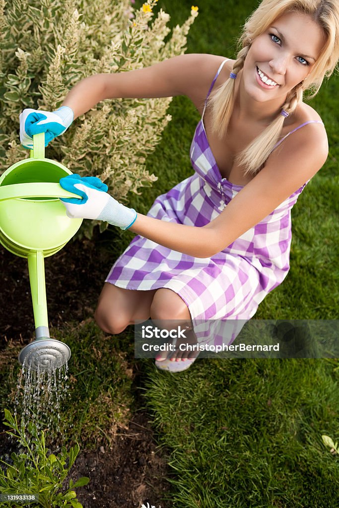 Uśmiechnięta kobieta polewanie the garden - Zbiór zdjęć royalty-free (20-24 lata)