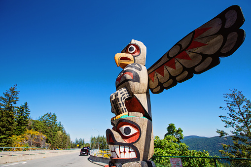 Malahat, Canada - June 21, 2021. A totem pole stands at the rest stop viewpoint at the summit of the Malahat.