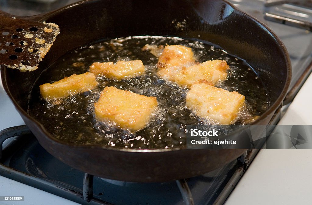 frying corn meal mush Corn meal mush - a traditional food of the south and Midwest - frying in okl in an iron skillet Fried Stock Photo