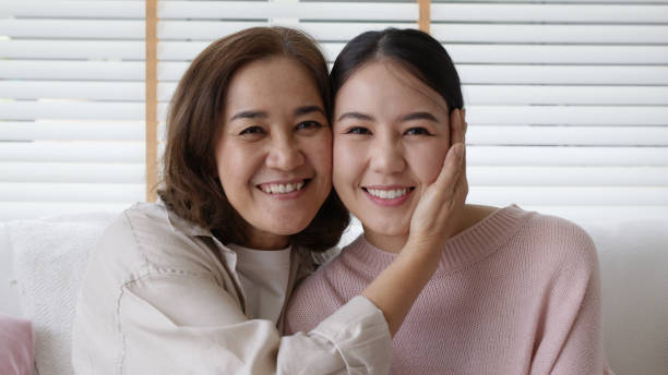 close up attractive beautiful two asia people face cheek smile to camera authentic real family mum and adult kid in woman power day, diverse ethnic people, genes genetics ginger mom skincare concept. - offspring child toothy smile beautiful imagens e fotografias de stock