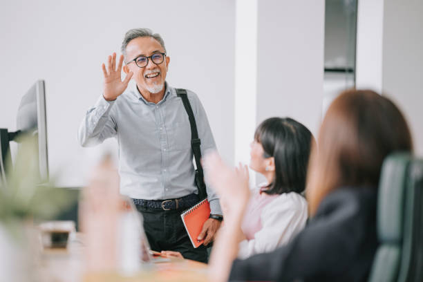 colega chino de trabajo de nuevo a trabajar con máscara facial saludándose unos a otros en la mañana de la oficina - businessman happiness carefree computer fotografías e imágenes de stock