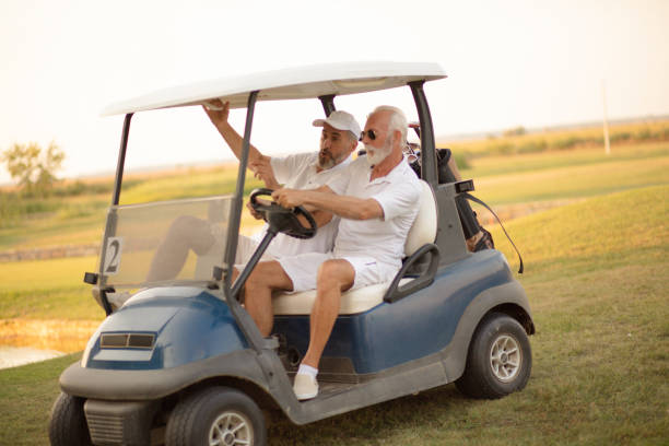 istock Two older friends are riding in a golf cart. 1319370924