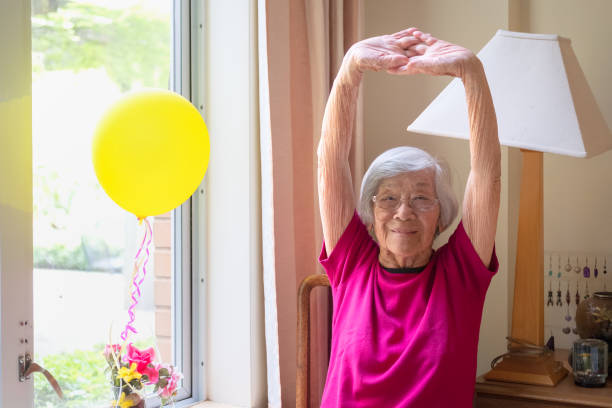 Senior Asian Woman in 90s Doing Stretching Exercises