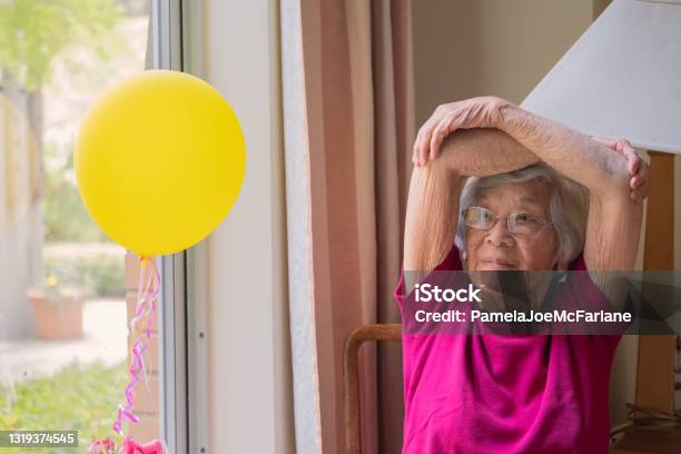 Asian 90s Senior Woman Doing Chair Stretching Exercises At Home Stock Photo - Download Image Now