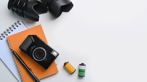 istock High view of photographer workplace with camera, notebook and copy space on white table. 1319375579