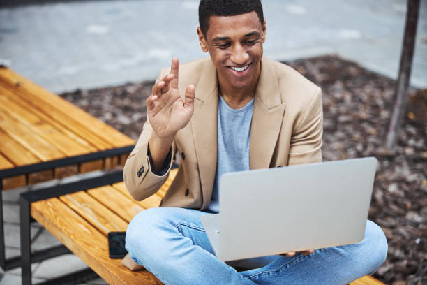 istock Kind dark-skinned man having online meeting outside 1319376860