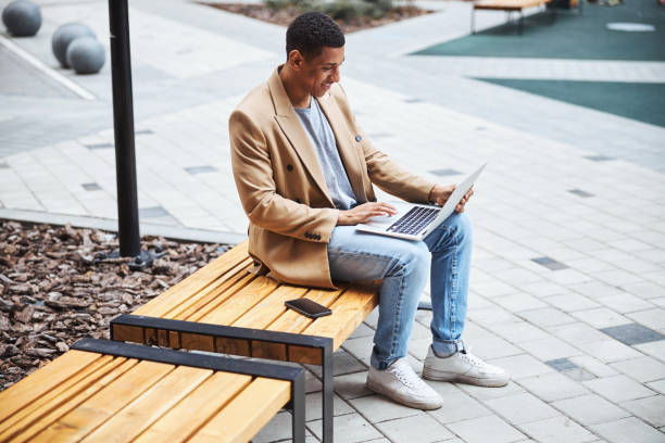 istock Delighted international man typing message on laptop 1319376957