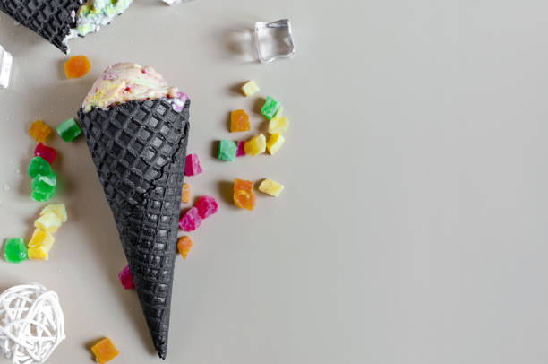 istock Ice cream in a dark waffle cup on a light background top view. Walrus flat ley. 1319383997
