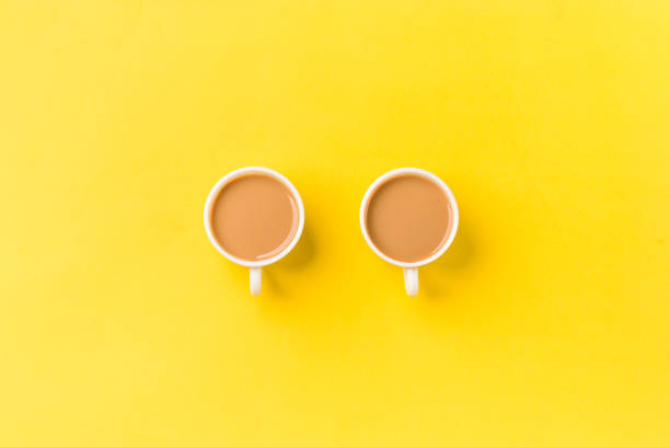 istock Milk tea on white cup with white kettle on yellow background stock image. 1319386760