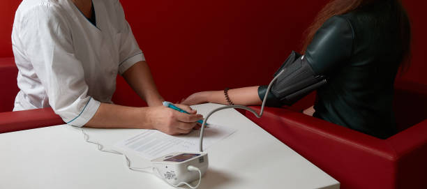 The doctor measures the pressure. At the doctor's appointment at the hospital. Taking care of your health. stock photo