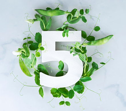 Layout with sprouts of green peas, leaves and number. Top view