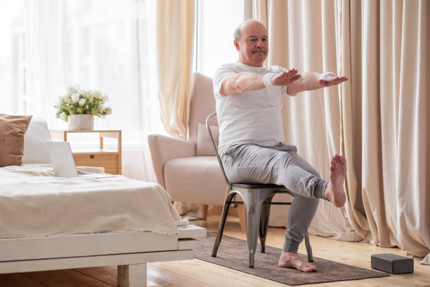 anciano practicando yoga asana o ejercicio deportivo para piernas y manos en la silla - power chair fotografías e imágenes de stock