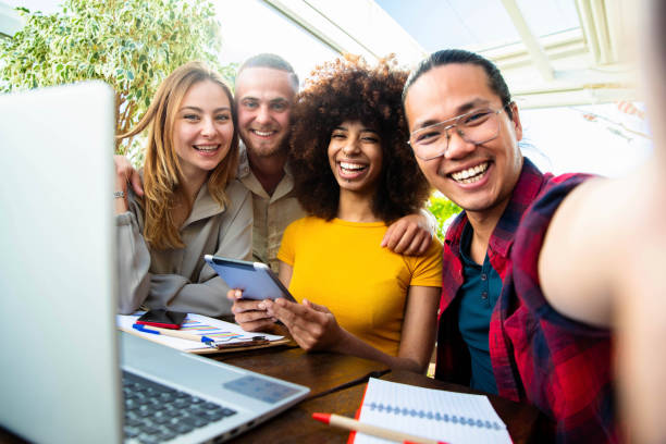 istock International young team work taking a selfie in creative office - Group of multiracial students using digital devices - Networking and e learning concept 1319396879