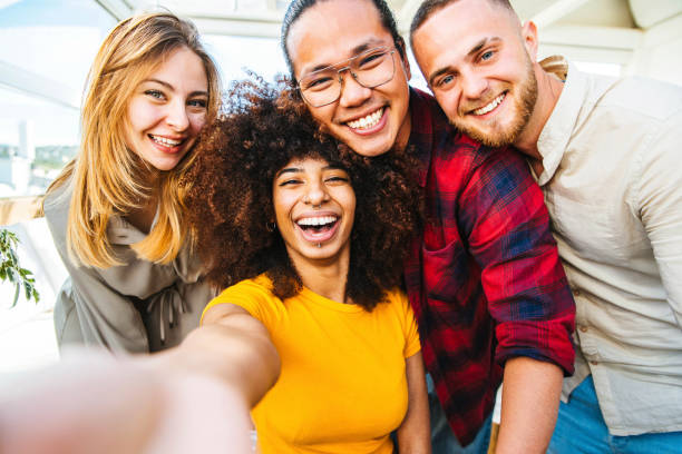 groupe multiculturel d’amis prenant un selfie avec la femme africaine au premier plan - concept d’amitié avec des jeunes souriant à l’appareil-photo - focus sur la fille noire - humor men laughing teenager photos et images de collection