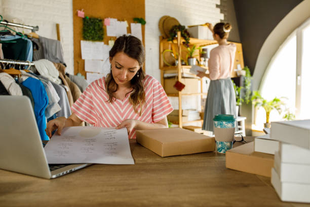 istock Young woman peeling off labels and applying them on packages 1319404691