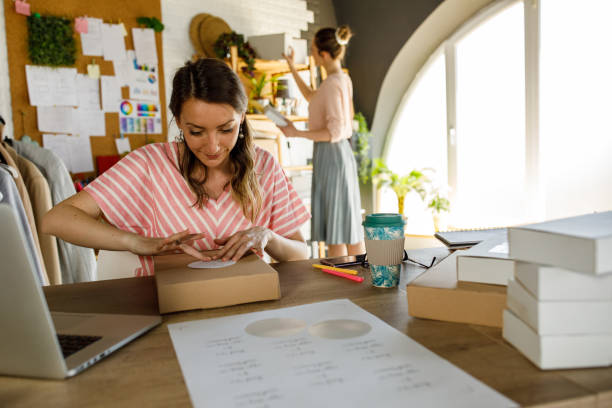 istock Young woman sitting at her desk and applying a label on a package 1319404729