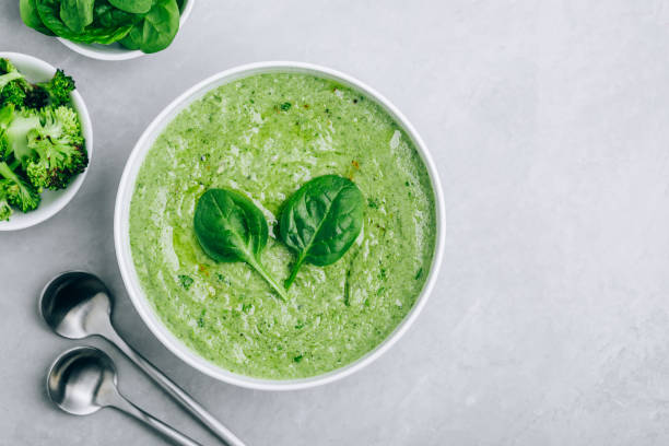 istock Green creamy spinach and broccoli soup on a gray concrete background. 1319404937