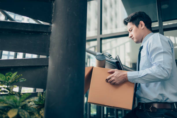 los desempleados sostienen caja de cartón y bolsa de ordenador portátil, dossier y tubo de dibujo en la caja. dejar un trabajo, el empresario despedido o dejar un concepto de trabajo. - unemployment benefits rejection application form fotografías e imágenes de stock