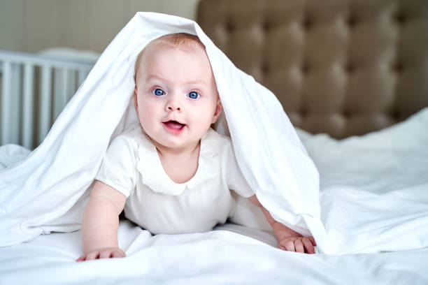 istock a small child with blue eyes lies on a white bed 1319412744