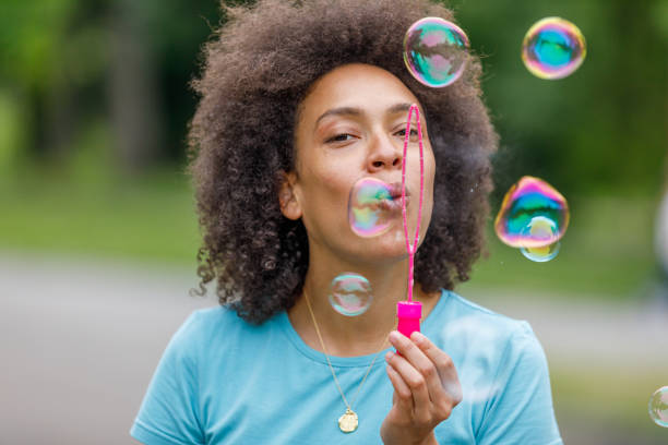istock Mother is Enjoying the Time in Public Park While Blowing Bubbles. 1319413564