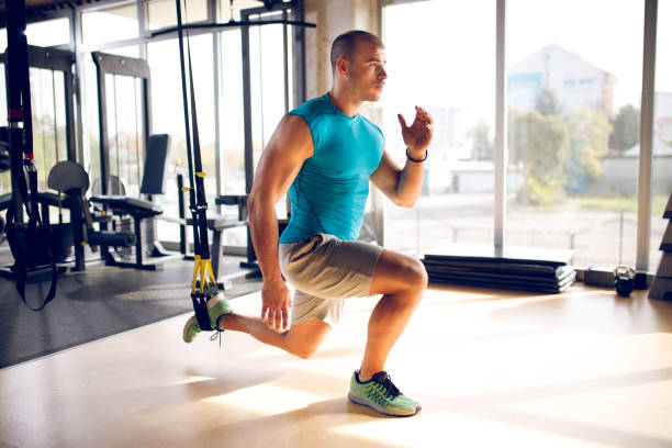 istock Man doing leg exercises with suspension straps at gym 1319416342