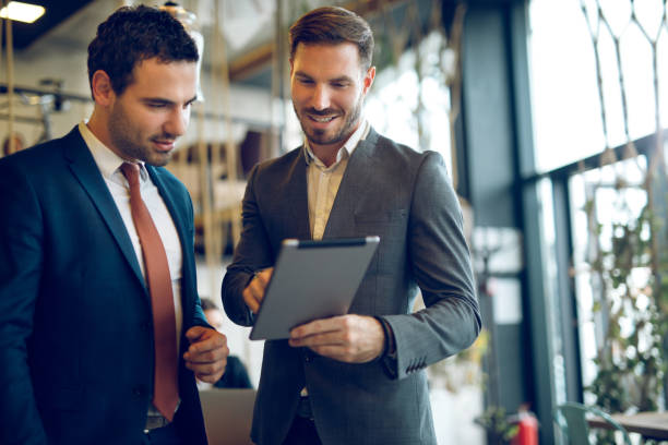 istock Two young businessmen discussing business strategy using digital tablet 1319416417