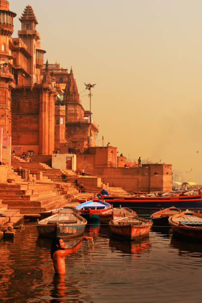 インドのウッタル・プラデーシュ州バラナシのガンジス川で入浴し、供物を作るインド人男性 - ancient architecture asia asian culture ストックフォトと画像