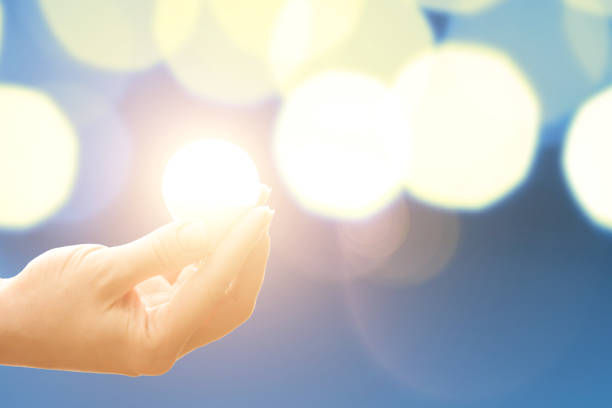 istock Lightbulb with light in hand illuminates background with circular lights,copy space 1319421928