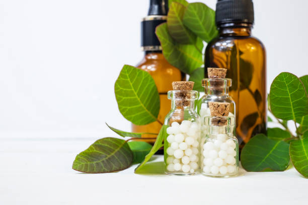 istock Homeopathic globules in small glass bottles on a white background. Homeopathy concept. 1319422054