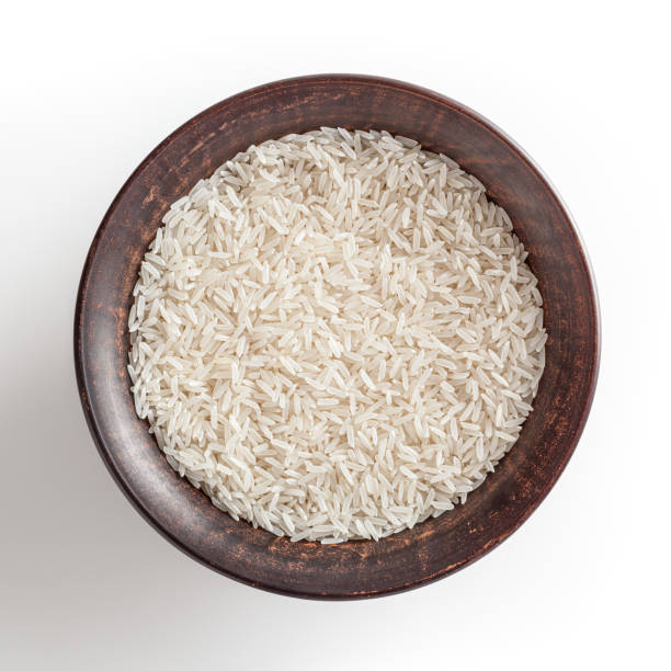 istock Uncooked jasmine rice in ceramic bowl isolated on white background 1319422669