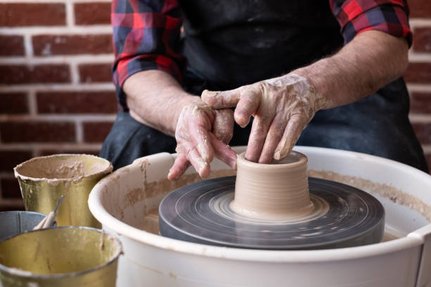 istock Potter wheel and hands of craftsman making a jug 1319423808