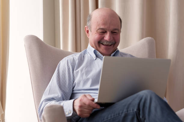 istock Senior man connected on internet with laptop at home 1319424089