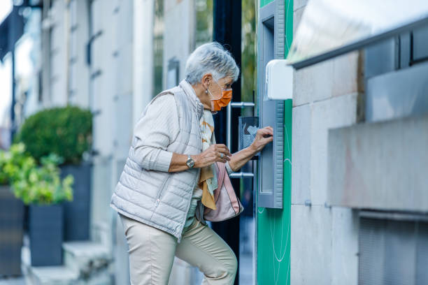 istock Senior Woman is Using ATM During a Pandemic Time. 1319431029