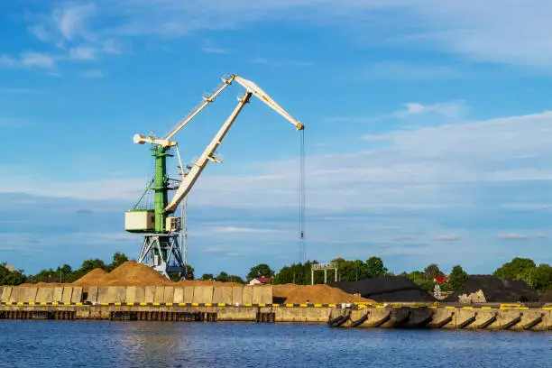 Photo of Cargo crane in terminal in river. Storage, port cranes, industrial scene.
