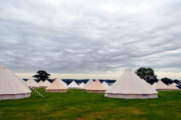 Field of bell tents A field of tents set up ready for a music festival under a dramatic sky. music festival camping summer vacations stock pictures, royalty-free photos & images
