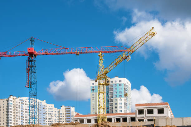 istock Red and yellow crane works on construction site 1319435696