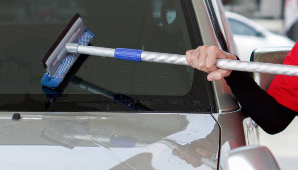 istock Gas station worker cleaning the car windshield with window squeegee. 1319436058