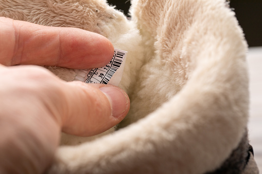 choose the right shoe size. what winter shoes to buy. man holds a label from shoes with fur