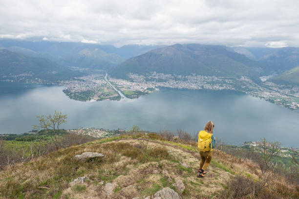 istock Young woman hiking on mountain ridge, overcast sky 1319438364