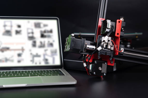 istock Installing a three dimensional or 3D printer by searching for information on the laptop via the Internet on black background. Wireless Technology. 1319446392