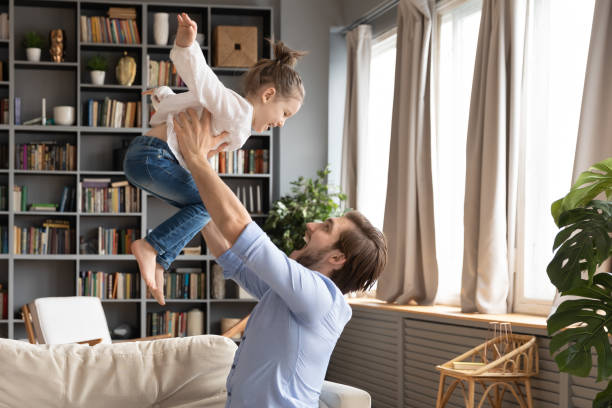 istock Happy dad play with excited small daughter at home 1319451789
