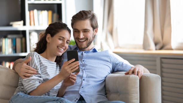 istock Smiling couple use smartphone talk on video call 1319451885