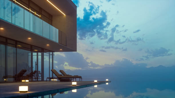 Modern Luxury House With Private Infinity Pool In Dusk Luxurious villa with private infinity pool and chaise lounges at summer in dusk. lounge chair photos stock pictures, royalty-free photos & images
